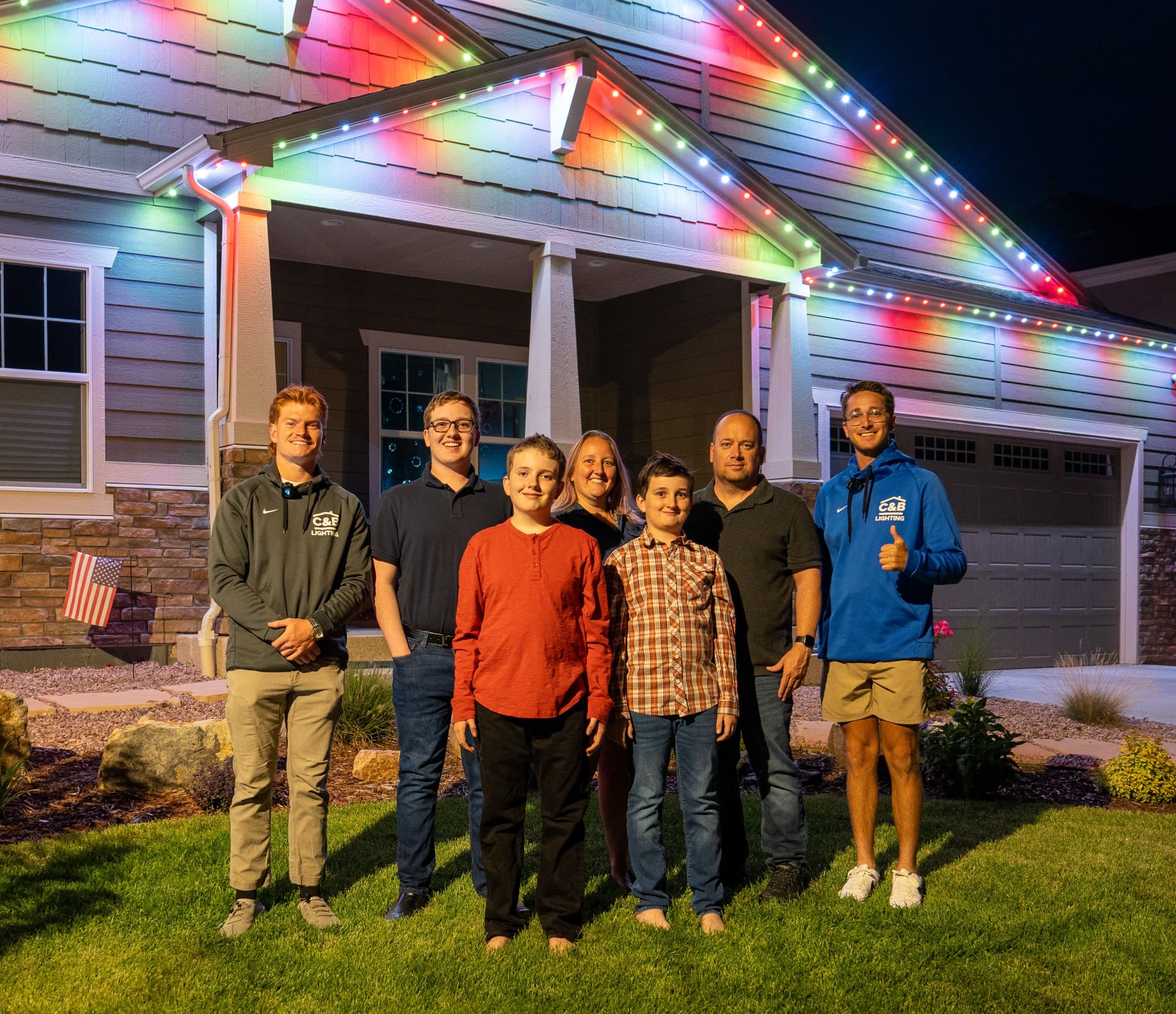 Solace Lighting customers in front of their beautifully lit home